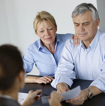 Senior couple signing financial contract
