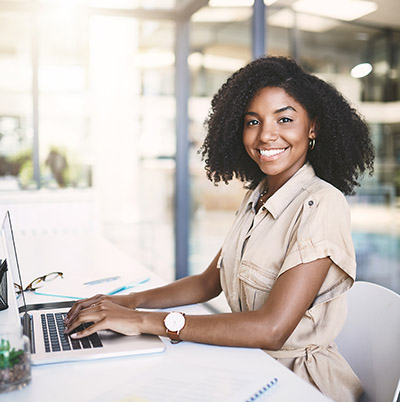 Success is a doing word. Portrait of a young businesswoman using a laptop at her desk in a modern office.